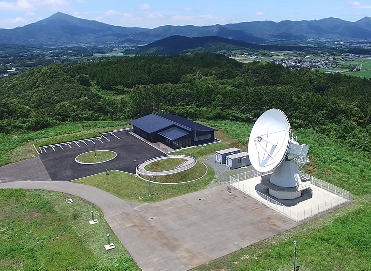 石岡測地観測局の全景（右側の白いパラボラ型アンテナが電波望遠鏡）出典：国土地理院ウェブサイト（https://www.gsi.go.jp/uchusokuchi/vlbi-igos.html）